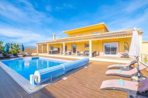 a villa with a swimming pool in front of a house at Villa Golden Bay by Algarve Vacation in Carvoeiro +42 photos