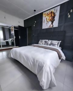 una grande camera da letto con un grande letto bianco di African Oak: Rosewood ad Arusha