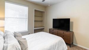 a bedroom with a bed and a flat screen tv at Landing Modern Apartment with Amazing Amenities (ID6588X72) in Richardson