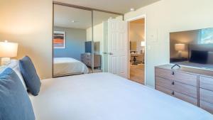 - une chambre avec un grand lit blanc et un miroir dans l'établissement Landing Modern Apartment with Amazing Amenities (ID8472X99), à Redmond