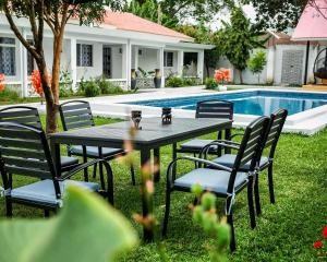 a table and chairs next to a swimming pool at African Oak: Rosewood in Arusha