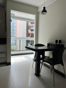 uma sala de jantar com uma mesa e cadeiras e uma janela em Ocean flat com vista pro mar 404 em Vila Velha