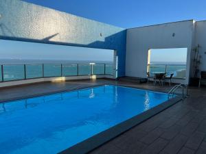 a swimming pool with a view of the ocean at Ocean flat com vista pro mar 404 in Vila Velha