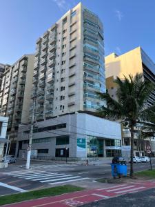 a large building with a palm tree in front of it at Ocean flat com vista pro mar 404 in Vila Velha