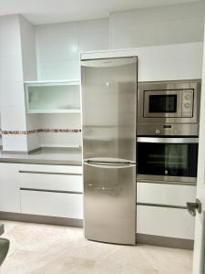 a stainless steel refrigerator in a white kitchen at Apartamento Espinel 47 in Ronda