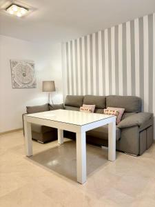 a living room with a white table and a couch at Apartamento Espinel 47 in Ronda