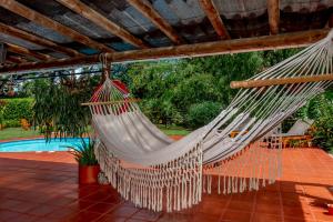基姆巴亞的住宿－Villa Alegre - Fincas Panaca，吊床挂在泳池旁的凉棚上