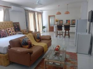 a large living room with a couch and a kitchen at Royal Eagles in Gaborone