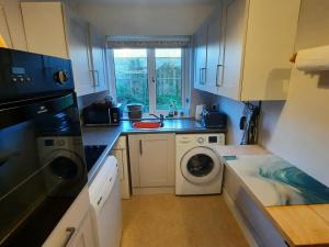 a kitchen with a washing machine and a sink at Cwmwdig Cwtch (3 minutes drive to Abereiddy bay!) in Haverfordwest