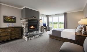 a bedroom with a bed and a fireplace at Auberge West Brome in West Brome