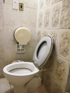 łazienka z toaletą z podniesioną siedziskiem w obiekcie Mangoty Apartamento w mieście Luque