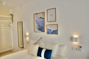 a room with a white couch and some pictures on the wall at Benalbeach Zafiro by C&N in Benalmádena +56 photos