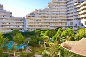 a large building with palm trees and a resort at Benalbeach Zafiro by C&N in Benalmádena