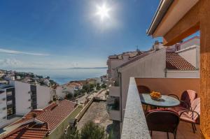a balcony with a table and chairs overlooking the ocean at Apartments Vlado in Trogir