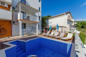 a swimming pool in front of a building at Apartments Vlado in Trogir