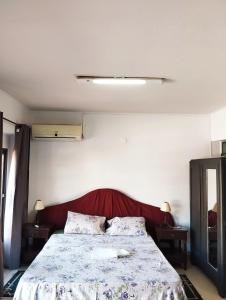 1 dormitorio con 1 cama grande y cabecero rojo en Mangoty Apartamento, en Luque