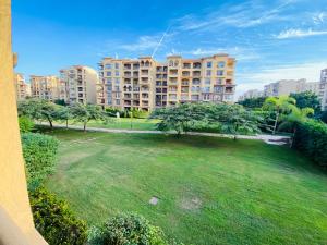 un grand parc avec un grand bâtiment en arrière-plan dans l'établissement Madinaty - مدينتي, à Madinaty