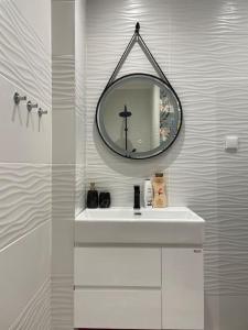 a white bathroom with a sink and a mirror at 3 BR Apt, Spacious, Near South Park in Sofia