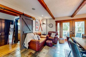 a living room with a leather couch and a table at Pura Via: Southern Charm - Suite B in Blue Mountains