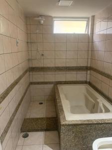 ein Badezimmer mit einer Badewanne und einem Waschbecken in der Unterkunft Apt para 3 pessoas no centro do Recife in Recife