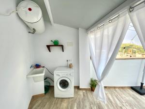 lavadero con lavadora y ventana en Casa La Romera, en Cazorla
