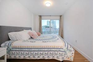 a bedroom with a large bed with a window at new apartment 3 bedrooms in Richmond