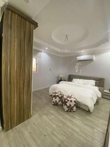a bedroom with a large bed and a large window at الثمد ..خيبر الشمالية in Al Thamad