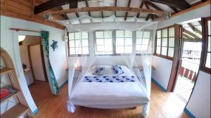 a bedroom with a bed with a canopy at Fare Oviri Lodge in Opoa