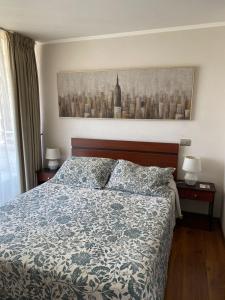 a bedroom with a bed and a painting on the wall at Apartamento Viña del Mar 1270 in Viña del Mar