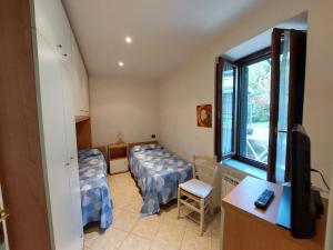 a small room with two beds and a window at Casa Bianca in Pietrasanta