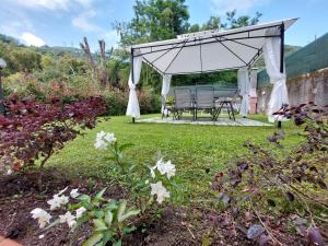 a gazebo with a table and chairs in a garden at Casa Bianca in Pietrasanta