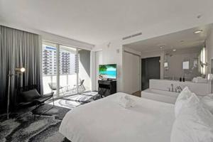 フォート・ローダーデールにあるWVR Vacation Residences 709のベッドルーム(大型ベッド1台付)、リビングルームが備わります。