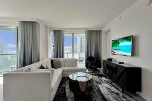 a living room with a white couch and a tv at WVR Vacation Residences 709 in Fort Lauderdale