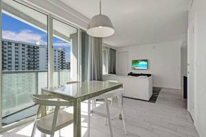 a dining room with a glass table and chairs in a living room at WVR Vacation Residences 709 in Fort Lauderdale +51 photos