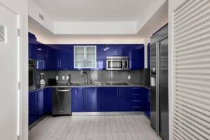 a large kitchen with blue cabinets and appliances at WVR Vacation Residences 709 in Fort Lauderdale