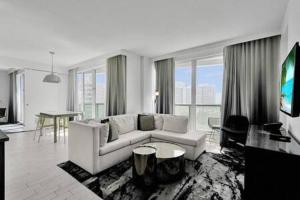 uma sala de estar com um sofá branco e uma mesa em WVR Vacation Residences 709 em Fort Lauderdale