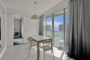 Una mesa y una silla en una habitación con balcón. en WVR Vacation Residences 709 en Fort Lauderdale