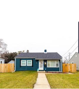 a blue house in a yard with a fence at 5 Min to Naval Base, Six Flags. in North Chicago