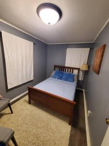 a bedroom with a bed with blue pillows on it at 5 Min to Naval Base, Six Flags. in North Chicago