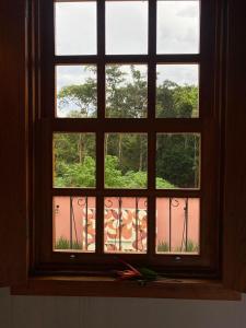 una ventana abierta con vistas al jardín en Pousada Mãe Natureza, en Pirenópolis