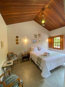 a bedroom with a large bed and a wooden ceiling at Pousada Mãe Natureza in Pirenópolis