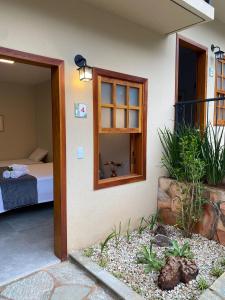 a room with a bed and a door with a window at Pousada Mãe Natureza in Pirenópolis