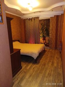 um quarto com uma cama e piso em madeira em Апартаменти район КРЕСа Сичеславська33 ''3кімн і 1кімн'' і Свирська1 "2кімн" em Krivoy Rog