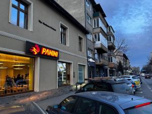 a parking lot with cars parked in front of a restaurant at elisio - Pani Nani Apartment in Braşov