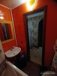 uma pequena casa de banho com um lavatório e um chuveiro em Апартаменти район КРЕСа Сичеславська33 ''3кімн і 1кімн'' і Свирська1 "2кімн" em Krivoy Rog