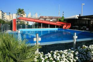 - une piscine avec un toboggan rouge dans l'établissement Hotel Locarno, à Cattolica