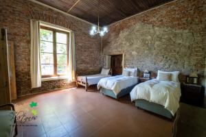 a bedroom with two beds and a stone wall at Estancia Los Plátanos in Valentines