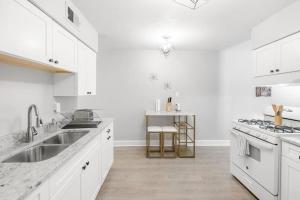 a white kitchen with a sink and a stove at Cozy King Suite Near Broad! in Memphis
