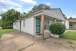 a white house with a green door and a yard at Cozy King Suite Near Broad! in Memphis