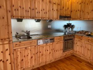 una cocina con armarios de madera y fregadero en Rigiana auf der Königin der Berge, en Rigi Kaltbad